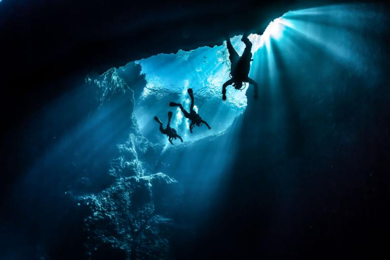 people cave diving under water