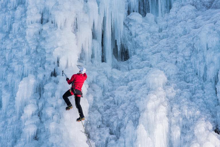 person hiking a frozen ice wall