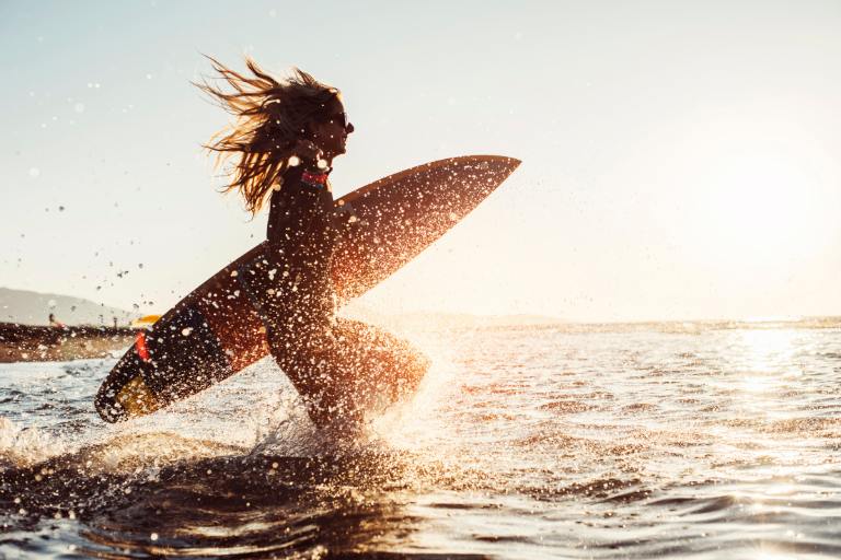 a woman holding a surfboard in the water